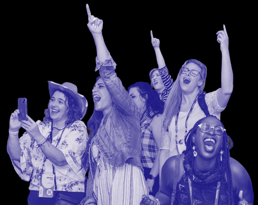 A group of excited attendees cheering, smiling, and raising their hands in celebration at Workhuman Live; one woman takes a photo on her phone while others shout and point upward.