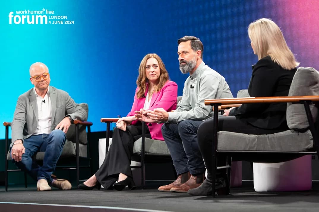 A panel of speakers discussing topics at the Workhuman Live Forum in London on June 4, 2024. Four individuals are seated on stage, with one man in glasses and a gray jacket, a woman in a pink blazer, another man in a gray shirt, and a woman in a black outfit. The background features a gradient design with the event branding prominently displayed.
